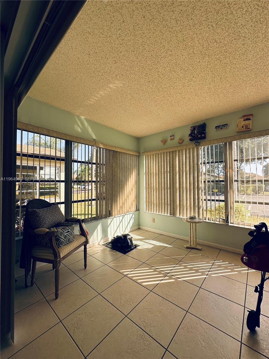 5260 Nesting Way, Unit B Delray Beach, FL 33484 - Photo 9 of 9 a living room with furniture and a floor to ceiling window