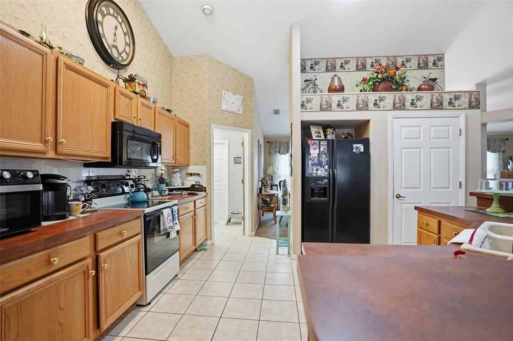 204 Planter Road Spring Hill, FL 34606 - Photo 12 of 45 a large kitchen with stainless steel appliances granite countertop a stove cabinets and a refrigerator