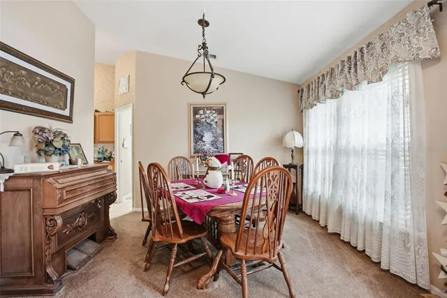 a dining room with furniture a chandelier and wooden floor