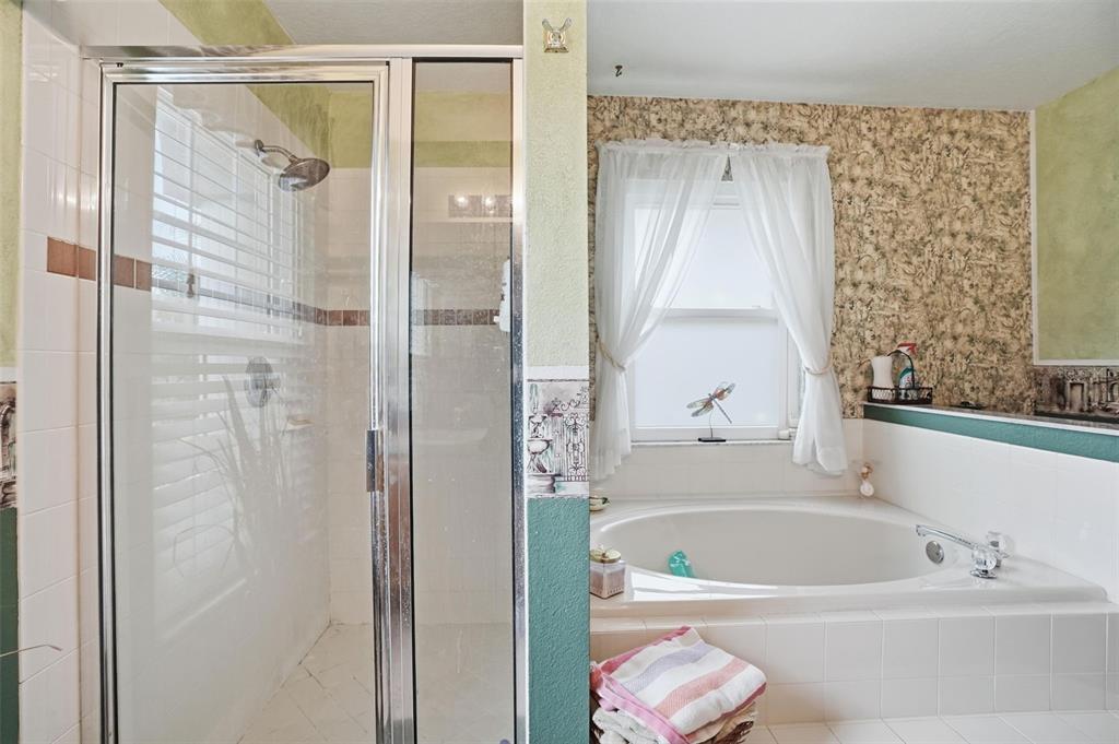 204 Planter Road Spring Hill, FL 34606 - Photo 30 of 45 a bathroom with a bathtub a shower and a sink