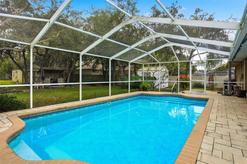204 Planter Road Spring Hill, FL 34606 - Photo 37 of 45 a view of a swimming pool with a large garden and wooden deck