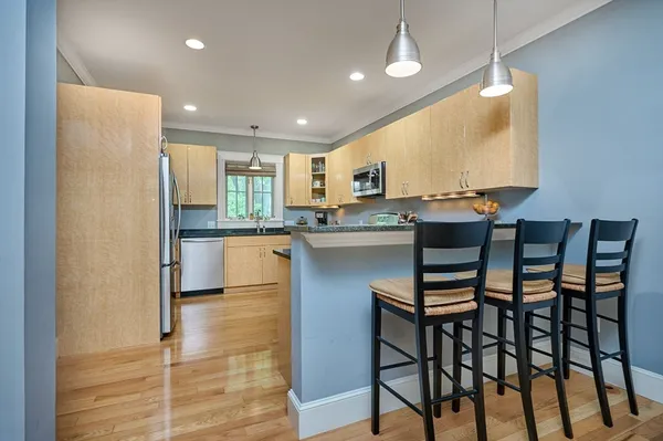 a kitchen with stainless steel appliances granite countertop table chairs sink and cabinets