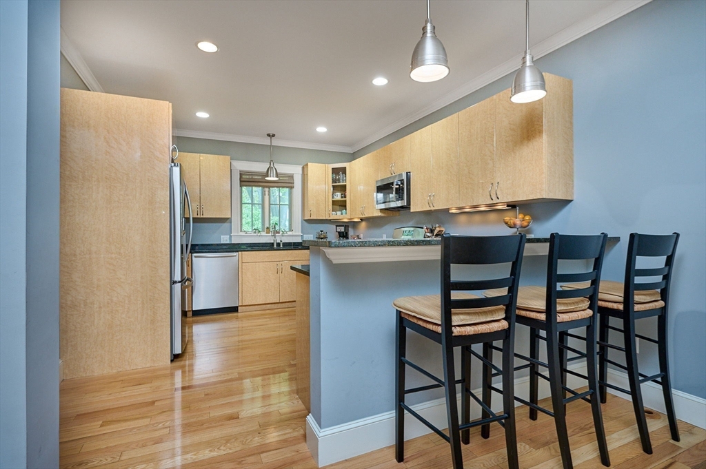 25 Union Street, Unit 2 Northampton, MA 01060 - Photo 14 of 38 a kitchen with stainless steel appliances granite countertop table chairs sink and cabinets