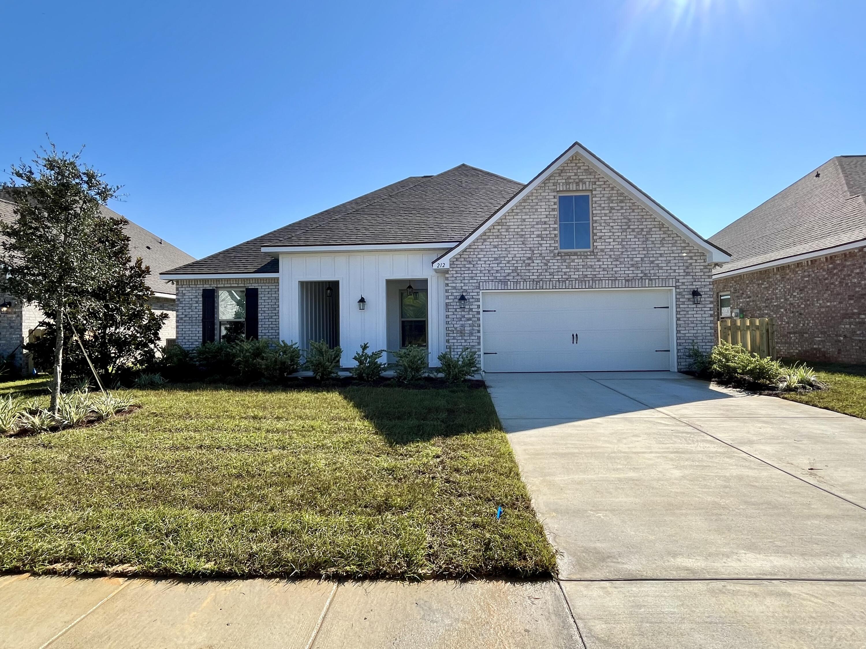 212 Lumen Loop Freeport, FL 32439 - Photo 1 of 3 a front view of a house with a yard and garage