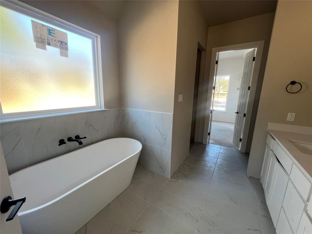 1053 Llano Way Poolville, TX 76487 - Photo 17 of 26 a bathroom with a bathtub and a sink