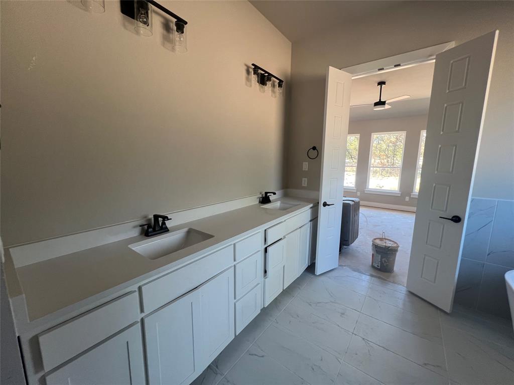 1053 Llano Way Poolville, TX 76487 - Photo 18 of 26 a spacious bathroom with a double vanity sink toilet mirror and bathtub