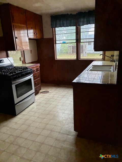 209 Highland Street Yoakum, TX 77995 - Photo 4 of 10 a kitchen with stainless steel appliances a stove a sink and a microwave