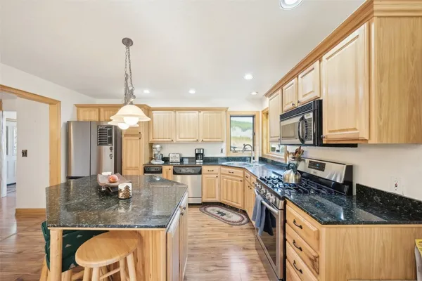 a kitchen with stainless steel appliances granite countertop a sink stove and cabinets