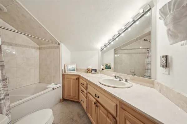 a bathroom with a granite countertop sink toilet tub and shower