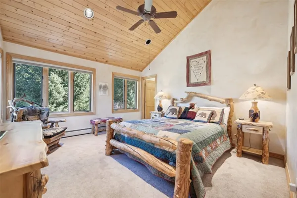 a bedroom with a bed couch and large window