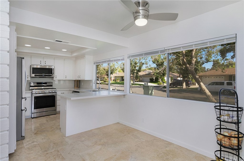 17241 Candleberry Irvine, CA 92612 - Photo 3 of 24 a kitchen with stainless steel appliances a stove top oven a sink and a refrigerator