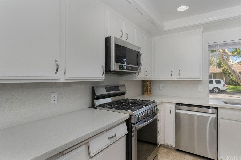 17241 Candleberry Irvine, CA 92612 - Photo 5 of 24 a kitchen with stainless steel appliances white cabinets and a stove top oven
