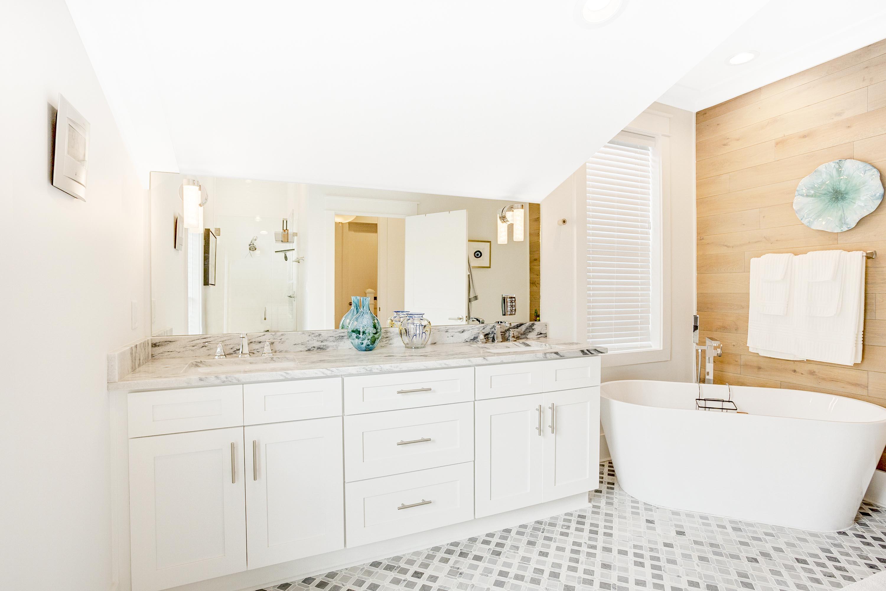 4795 Ocean Boulevard Destin, FL 32541 - Photo 18 of 43 a bathroom with a double vanity sink a mirror and a bathtub