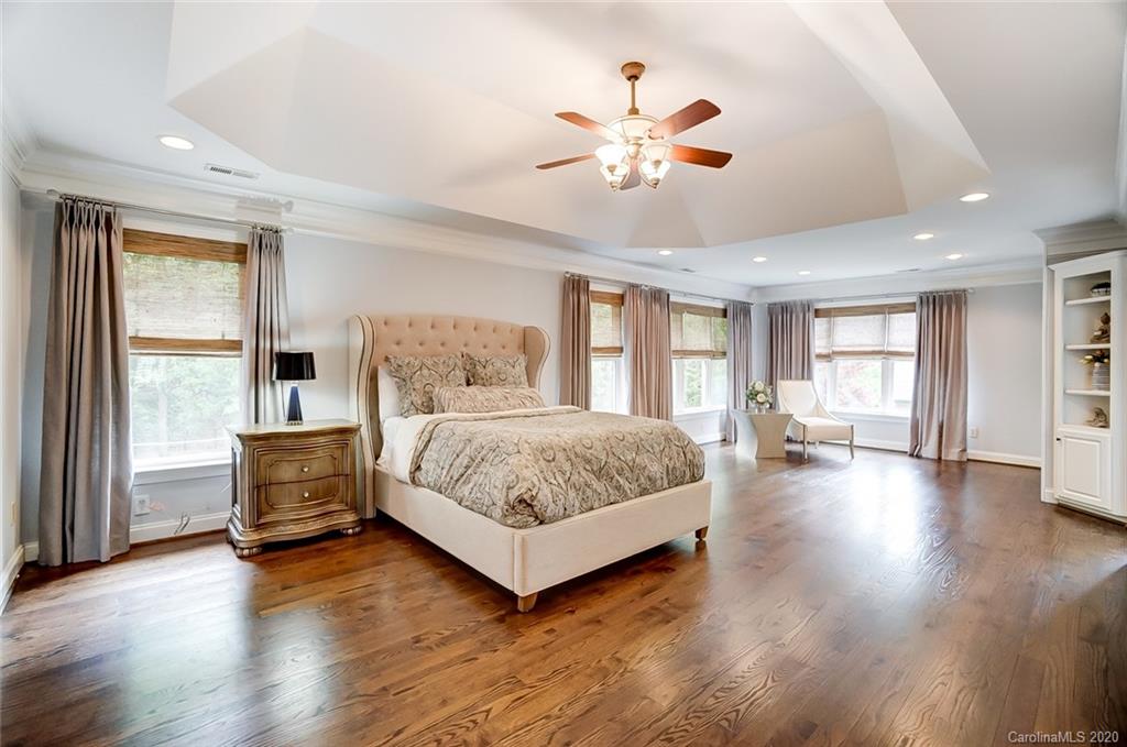 18408 Dembridge Drive, Unit 21 Davidson, NC 28036 - Photo 14 of 34 a spacious bedroom with a large bed and wooden floor