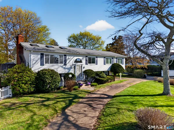 a front view of a house with a yard and potted plants