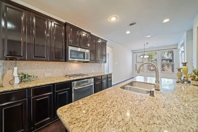 a kitchen with stainless steel appliances granite countertop sink stove and granite counter top