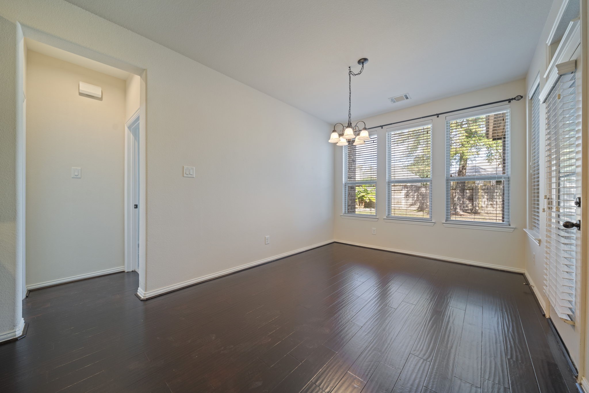 8115 Spreadwing Street Conroe, TX 77385 - Photo 20 of 45 a view of an empty room with wooden floor and a window
