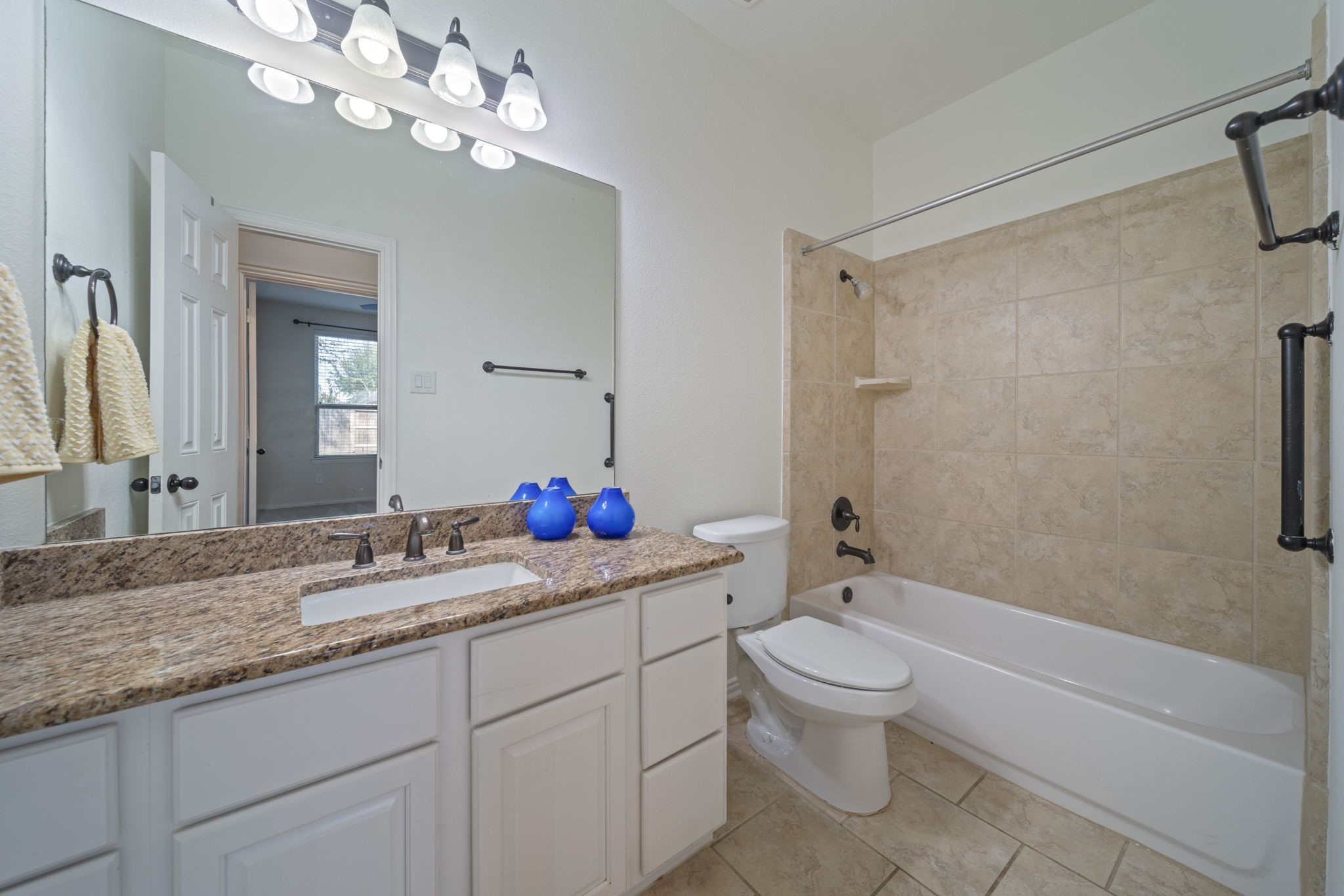 8115 Spreadwing Street Conroe, TX 77385 - Photo 22 of 45 a bathroom with a granite countertop sink a toilet and a mirror