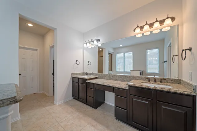 a bathroom with a granite countertop sink a large mirror and a shower