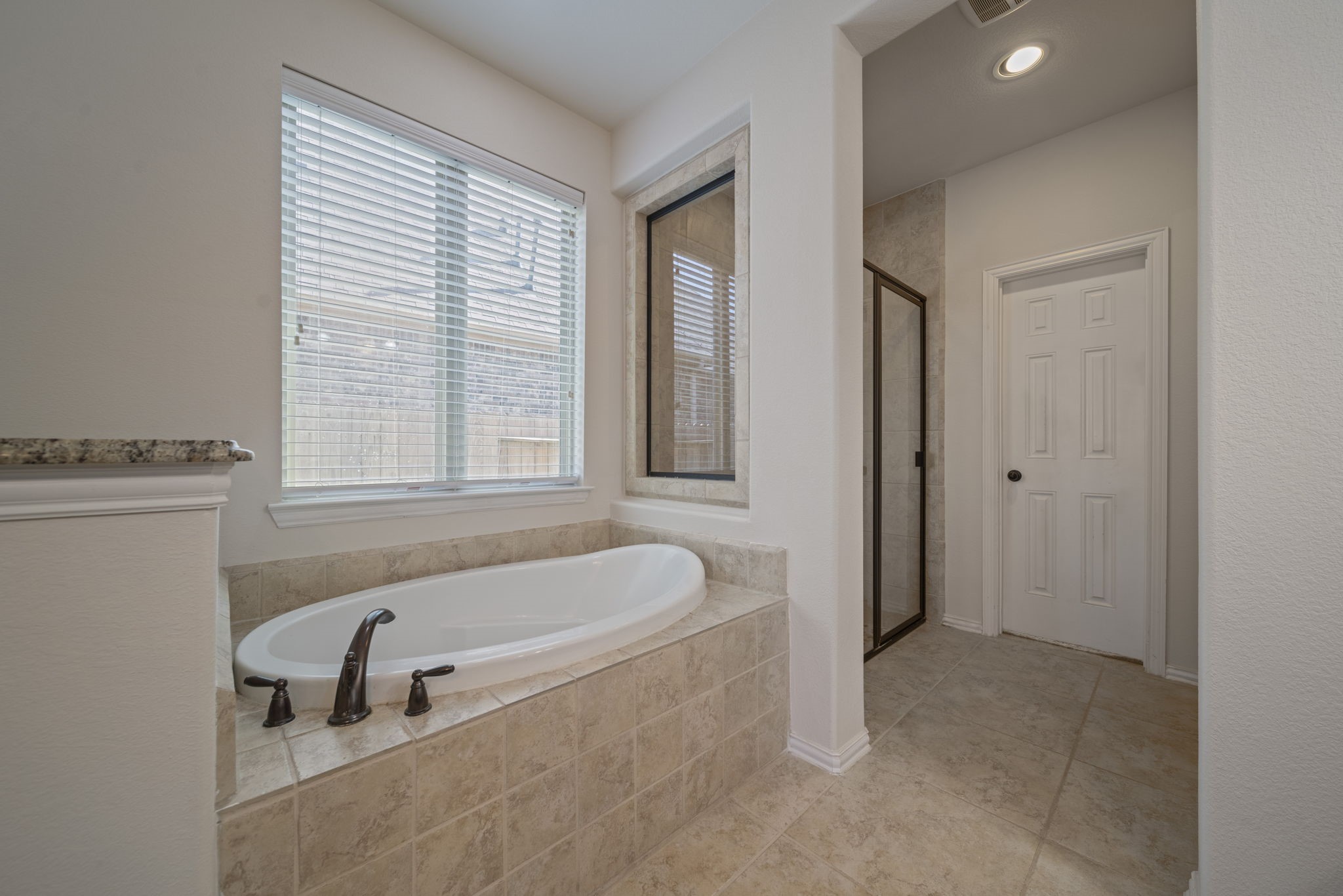 8115 Spreadwing Street Conroe, TX 77385 - Photo 29 of 45 a bathroom with a tub a sink and a window