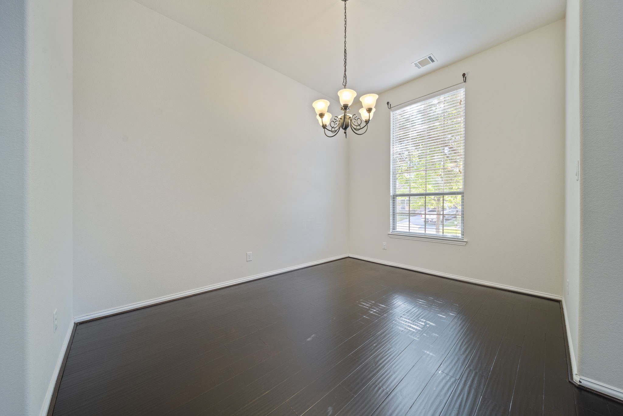8115 Spreadwing Street Conroe, TX 77385 - Photo 6 of 45 an empty room with wooden floor and window