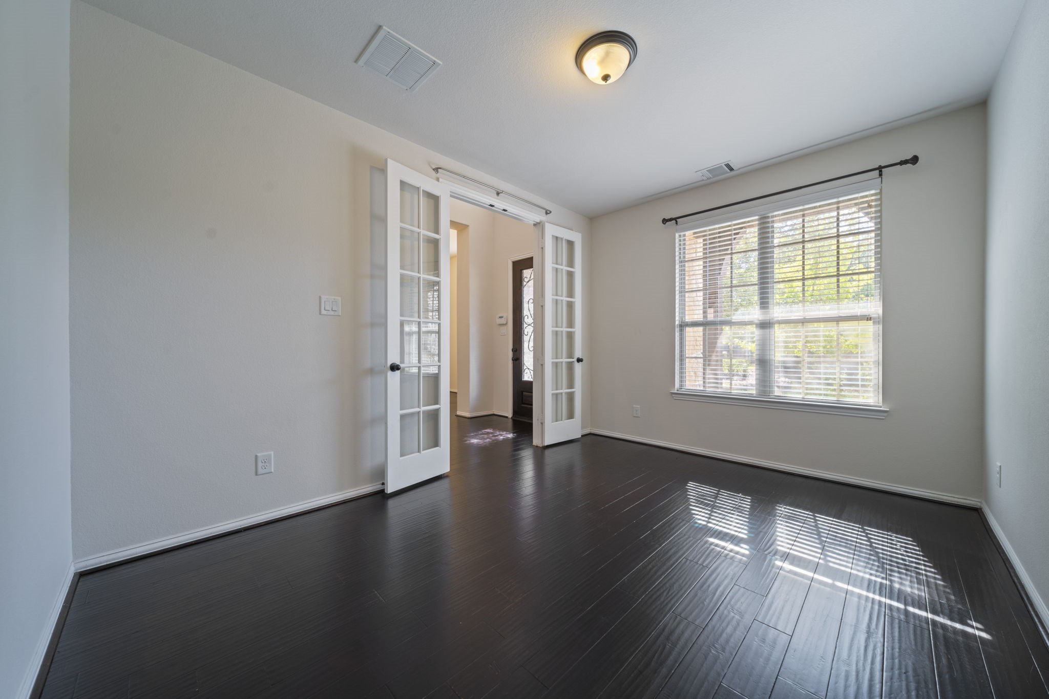 8115 Spreadwing Street Conroe, TX 77385 - Photo 9 of 45 an empty room with wooden floor and windows
