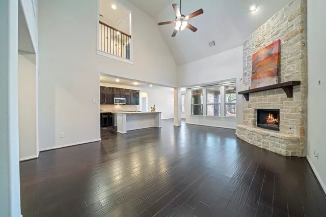 a view of an empty room with wooden floor and a fireplace