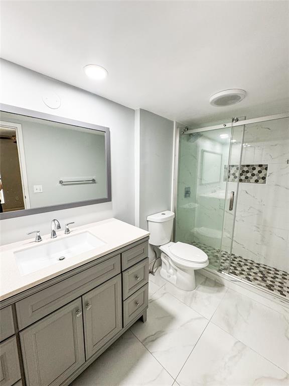 8351 Sands Point Boulevard, Unit A104 Tamarac, FL 33321 - Photo 13 of 18 a bathroom with a granite countertop sink toilet and shower