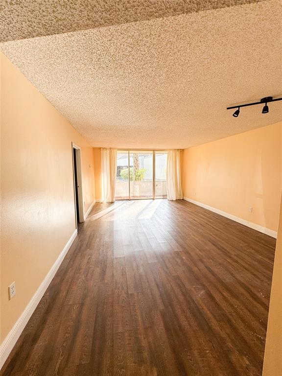 8351 Sands Point Boulevard, Unit A104 Tamarac, FL 33321 - Photo 8 of 18 wooden floor in an empty room with a window