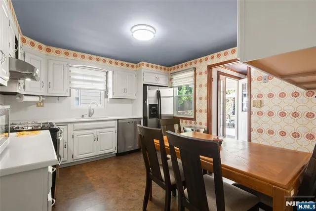 a kitchen with granite countertop cabinets stainless steel appliances a sink and a window
