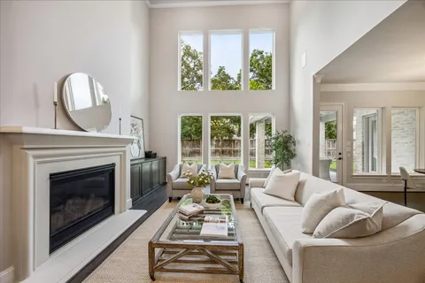 a living room with furniture a fireplace and a large window