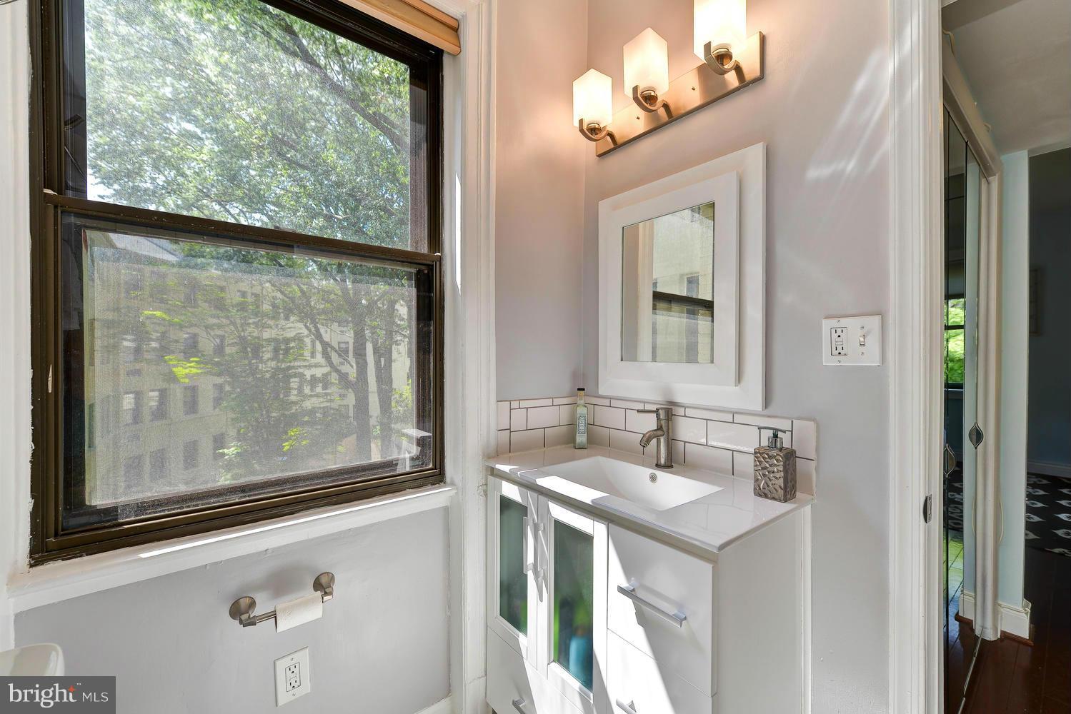 3100 Connecticut Avenue Northwest, Unit 304 Washington, DC 20008 - Photo 11 of 15 a bathroom with a sink mirror and a window