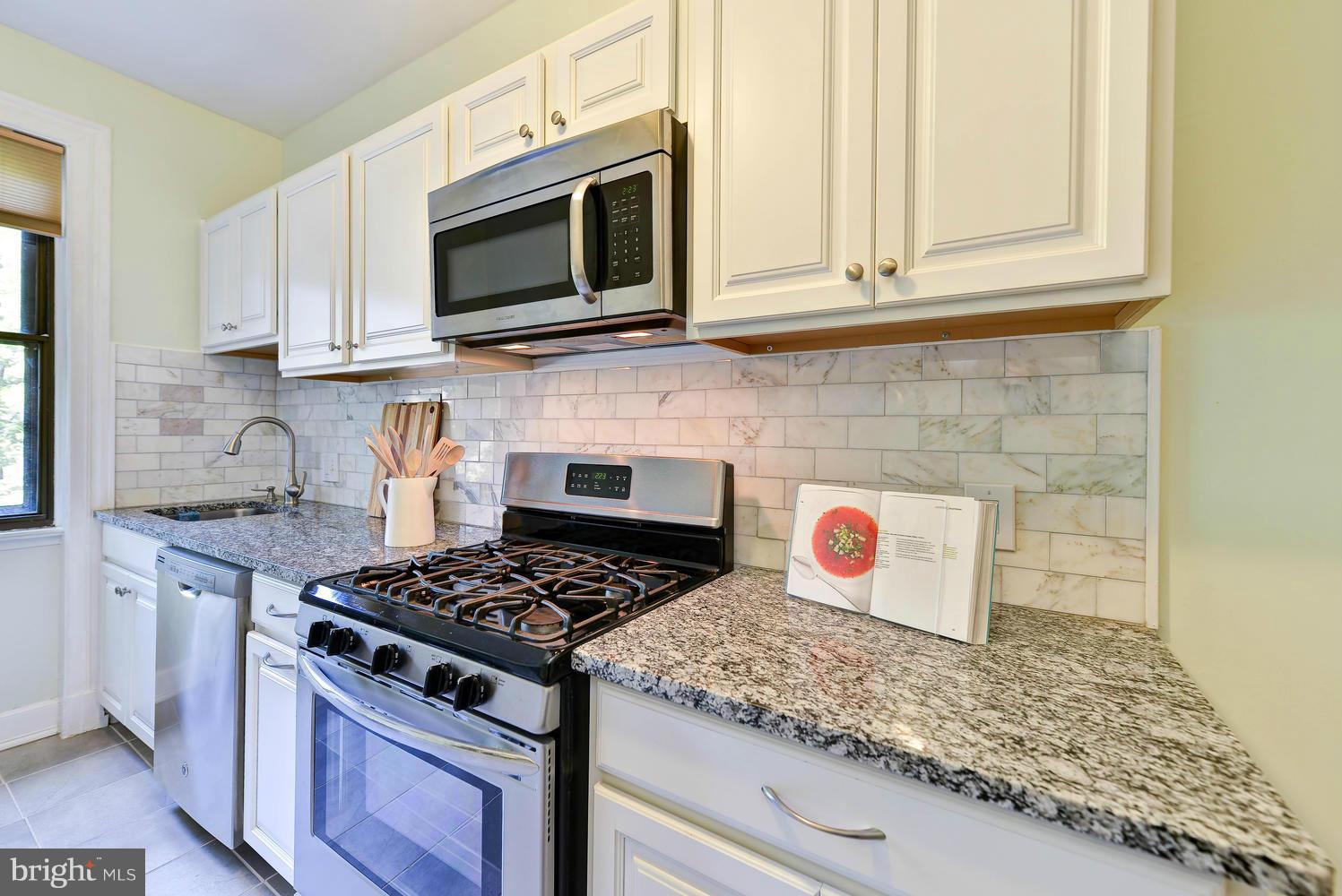 3100 Connecticut Avenue Northwest, Unit 304 Washington, DC 20008 - Photo 6 of 15 a kitchen with stainless steel appliances granite countertop a stove a microwave and cabinets