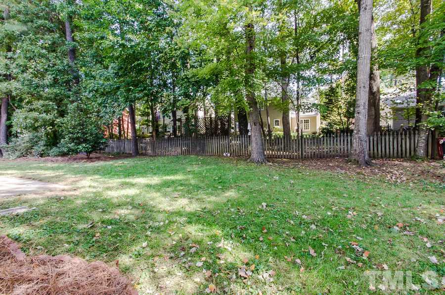 5521 Edgebury Road Raleigh, NC 27613 - Photo 19 of 19 a backyard of a house with lots of green space and glass windows
