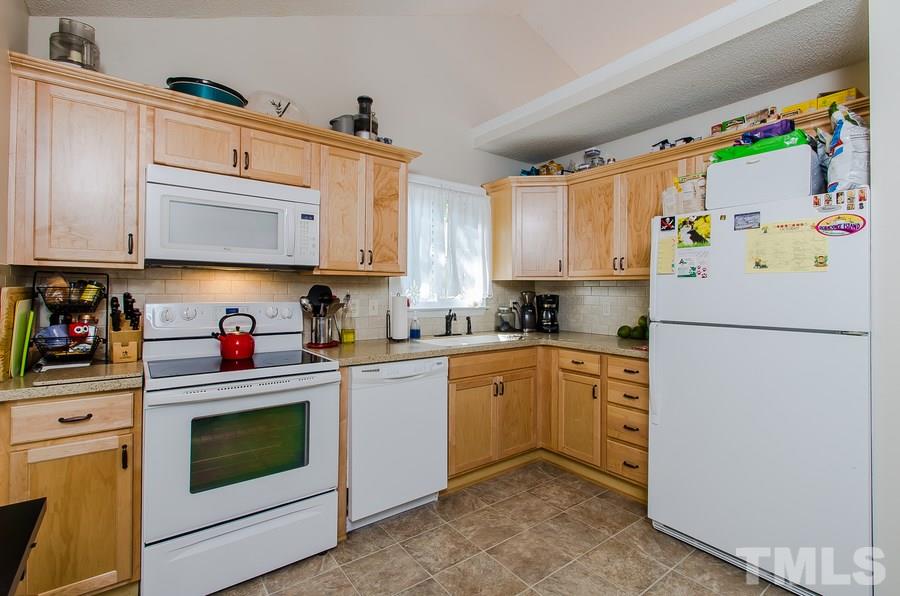 5521 Edgebury Road Raleigh, NC 27613 - Photo 7 of 19 a kitchen with stainless steel appliances granite countertop a refrigerator sink stove and white cabinets