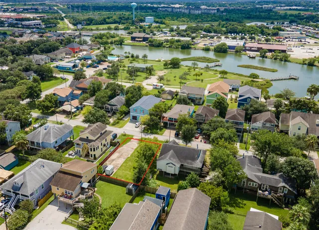 an aerial view of residential houses with outdoor space and lake view
