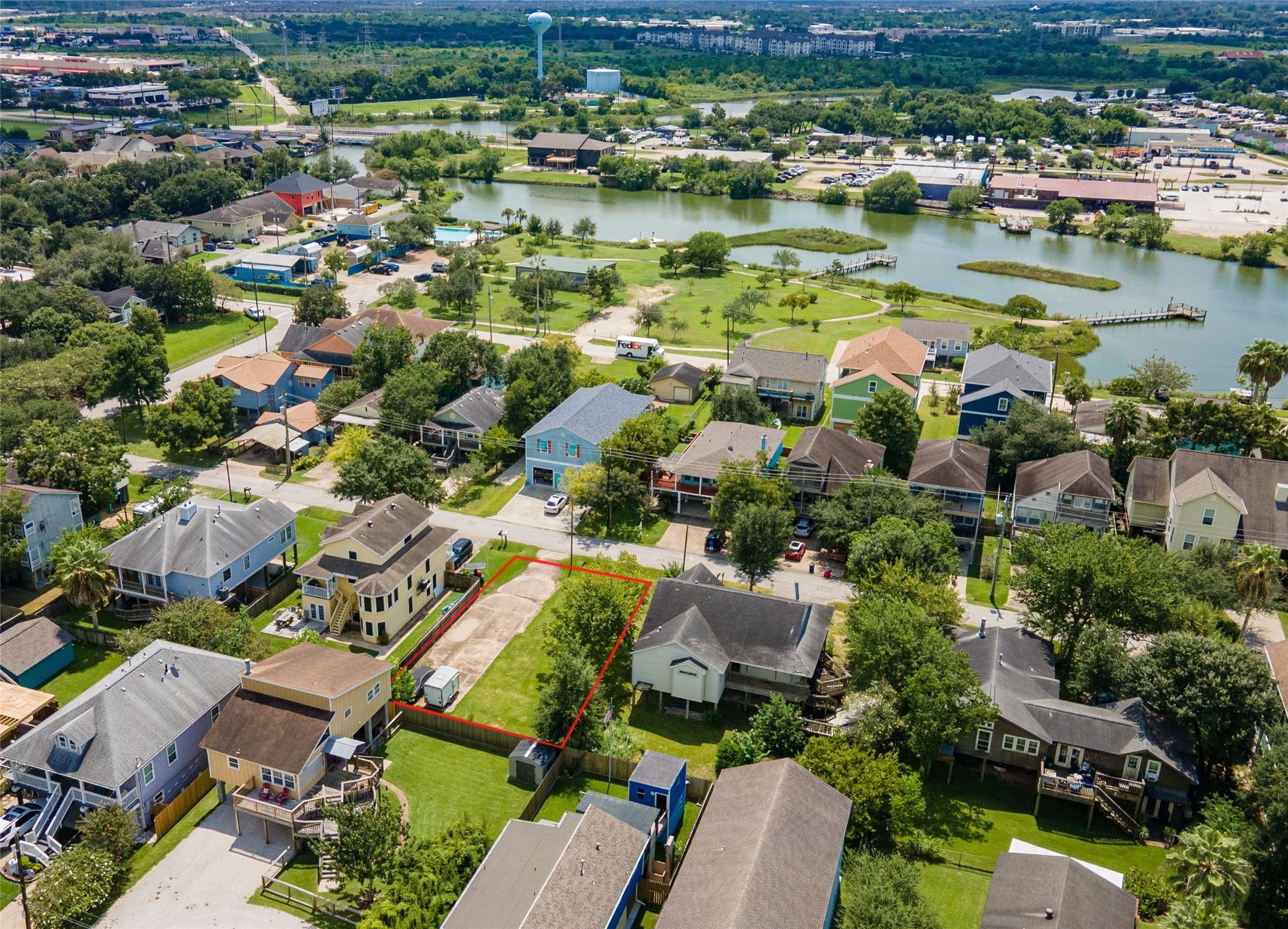 an aerial view of residential houses with outdoor space and lake view