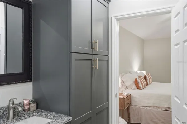 a bathroom with a granite countertop sink a mirror and shower