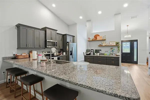 a kitchen with stainless steel appliances granite countertop a refrigerator stove and microwave