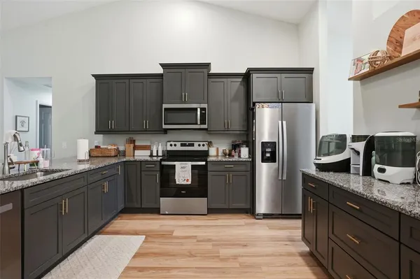 a kitchen with stainless steel appliances granite countertop a refrigerator and a stove top oven