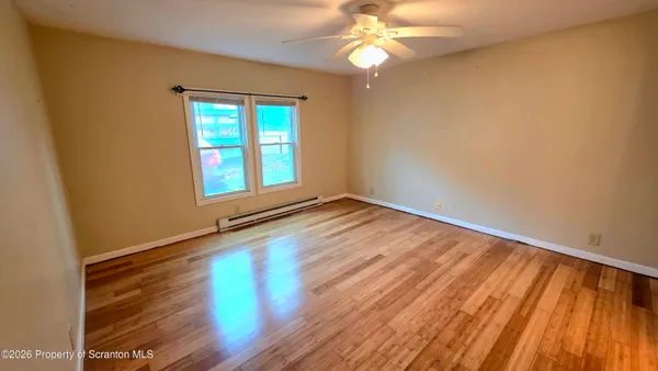 wooden floor in an empty room with a window