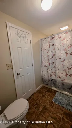 a bathroom with a toilet and a shower