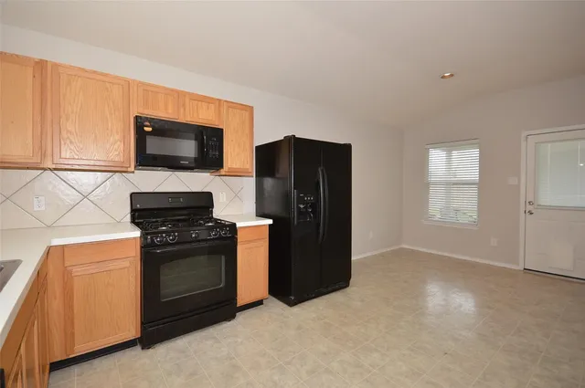 a kitchen with stainless steel appliances granite countertop a stove a refrigerator and a microwave