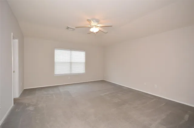 a view of a livingroom with a ceiling fan and window