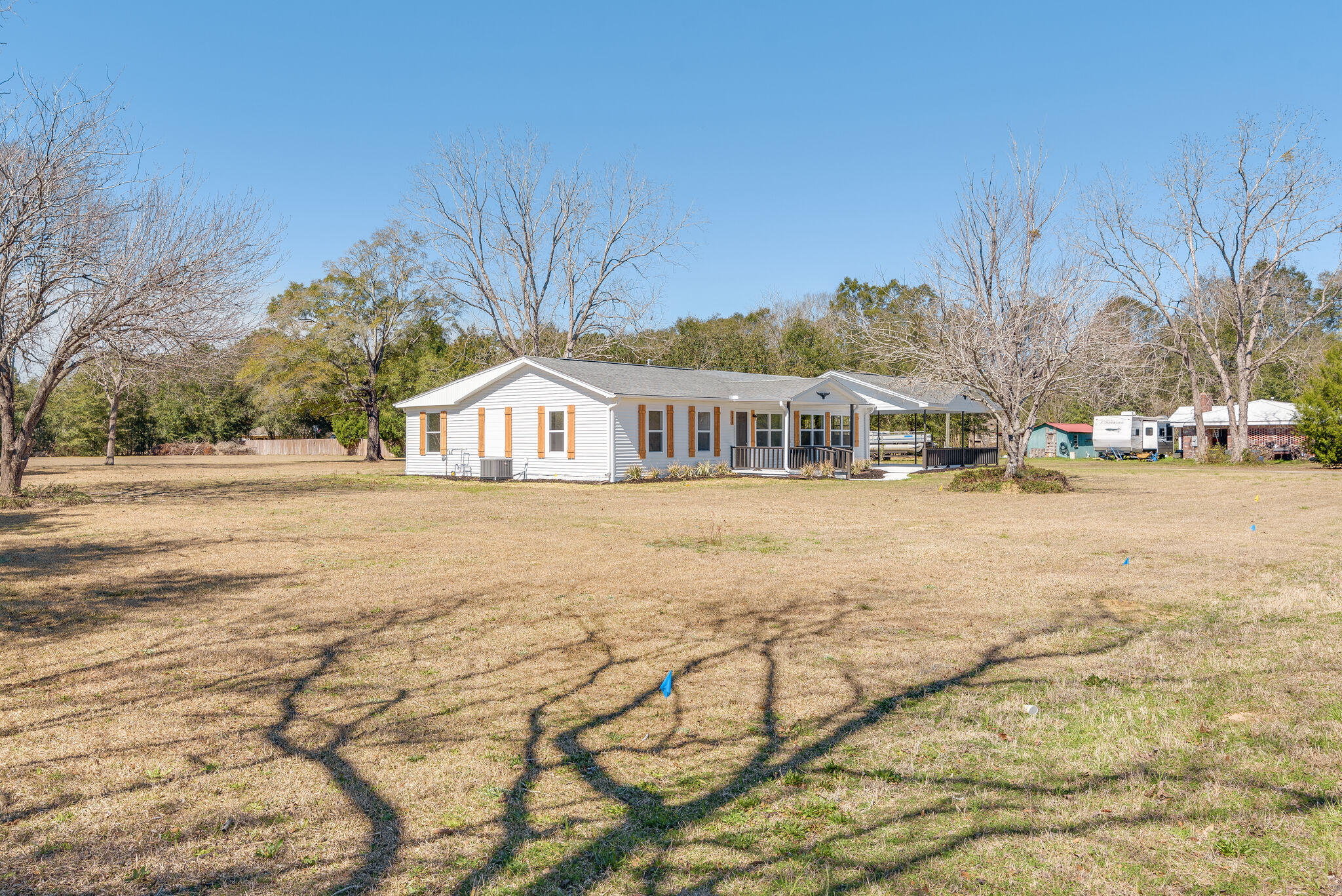 5238 Griffith Mill Road Baker, FL 32531 - Photo 3 of 34 a house view with tall trees and wooden fence