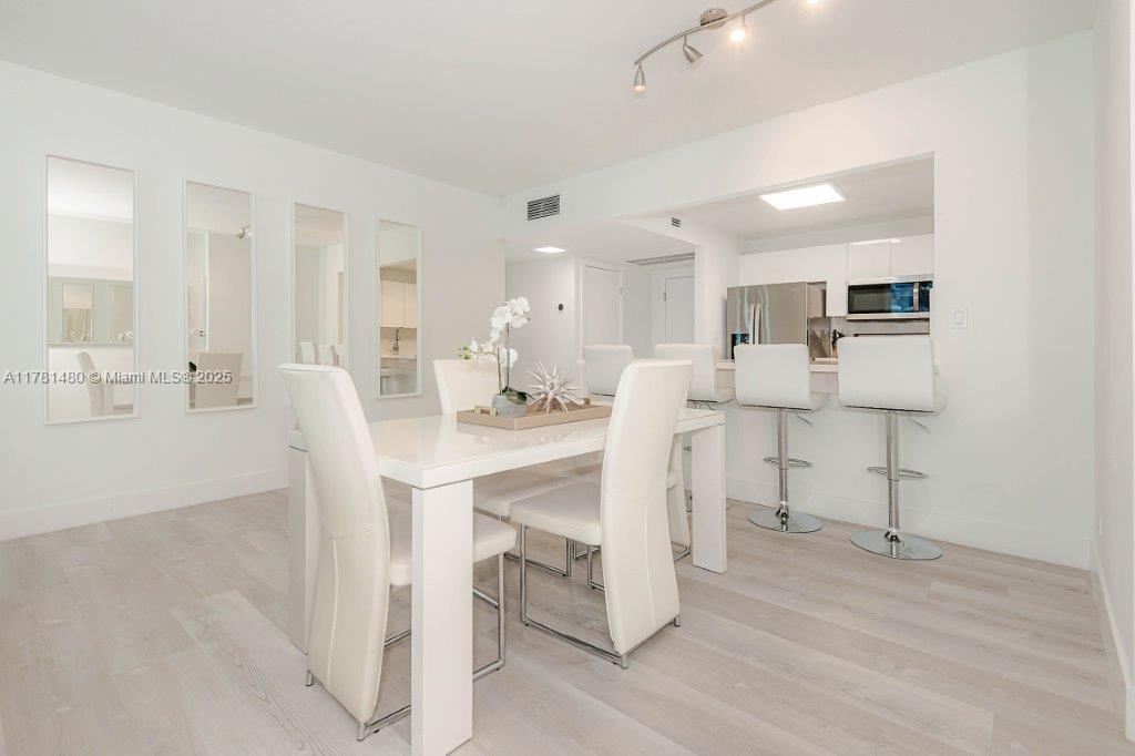2301 Collins Avenue, Unit 401 Miami Beach, FL 33139 - Photo 17 of 38 a living room with furniture a dining table and chairs