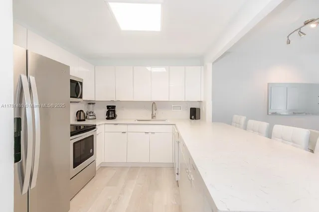 a kitchen with stainless steel appliances a refrigerator sink and microwave