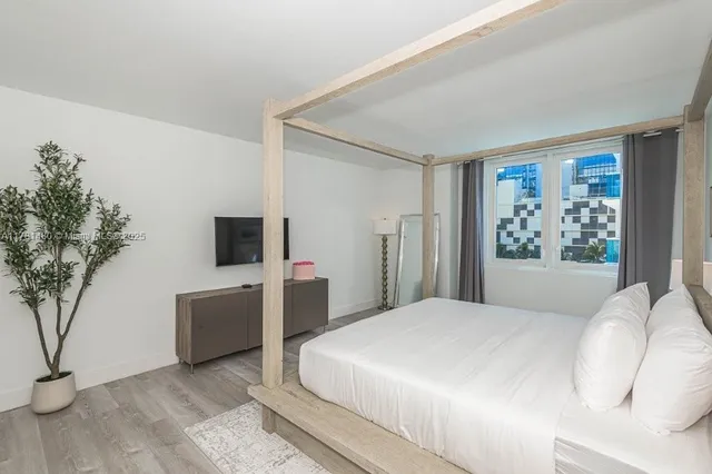 a bedroom with a large bed and a tv