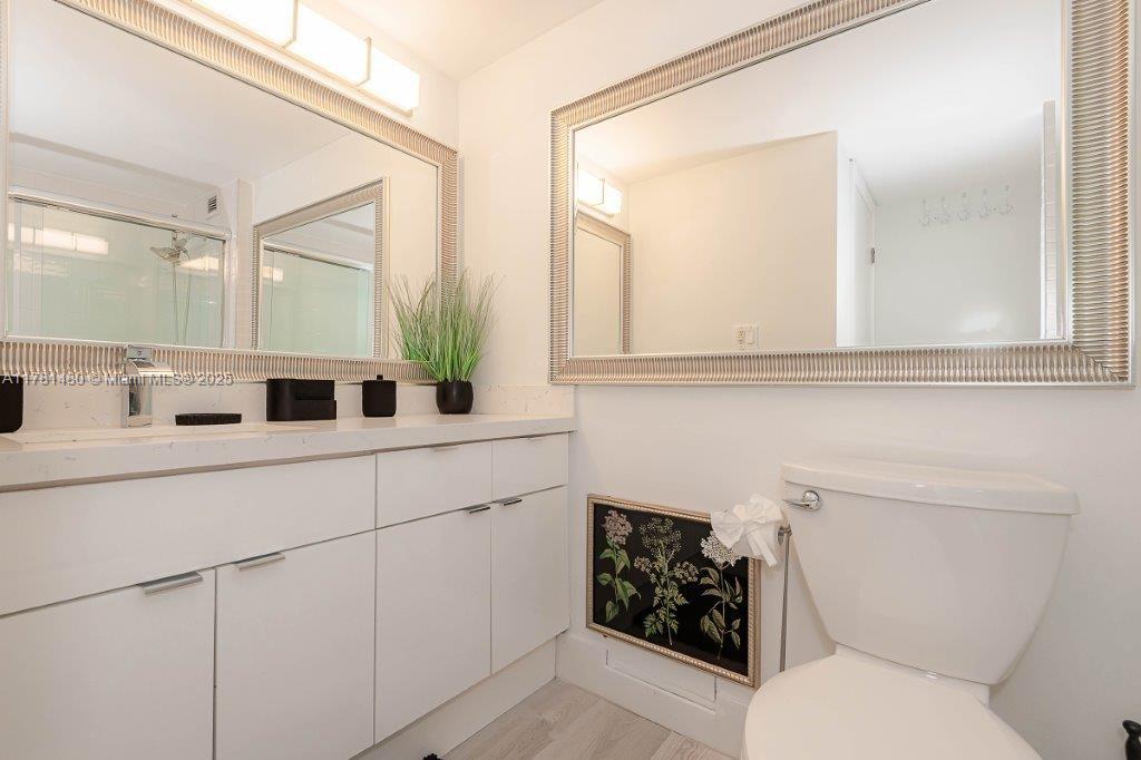 2301 Collins Avenue, Unit 401 Miami Beach, FL 33139 - Photo 5 of 38 a bathroom with a toilet sink and mirror