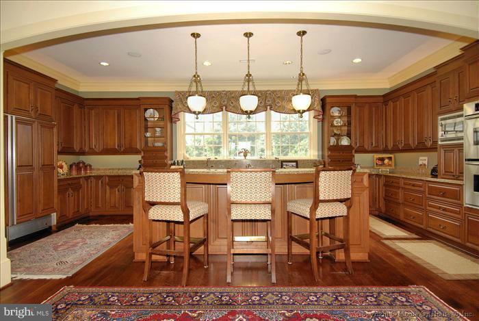 2121 Gadd Road Cockeysville, MD 21030 - Photo 11 of 28 a kitchen with stainless steel appliances kitchen island granite countertop a table chairs and wooden cabinets